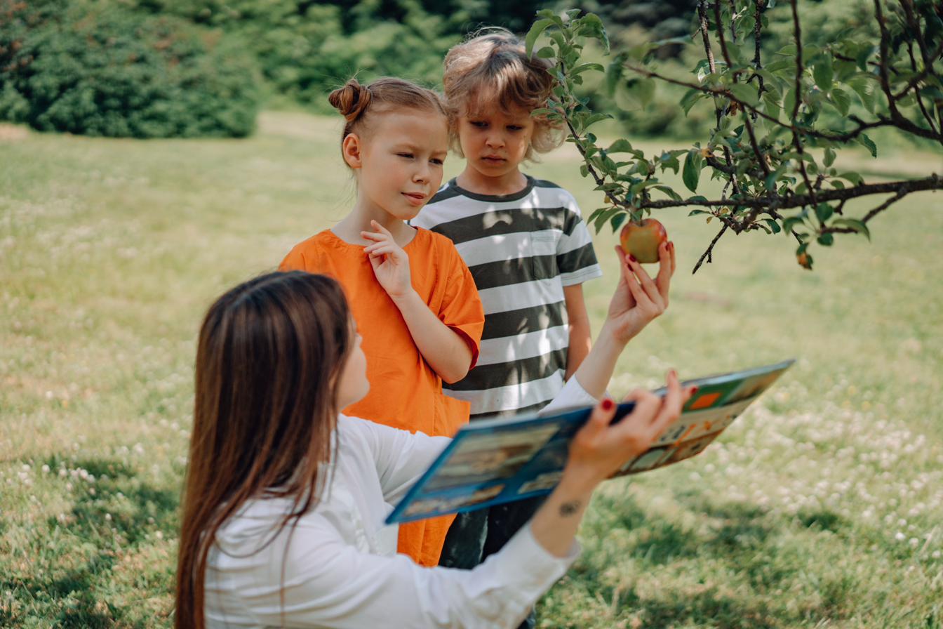 Teacher reading to children outdoors